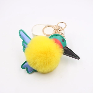 Detail of yellow plush hummingbird keychain with colorful PU leather wings and gold clasp