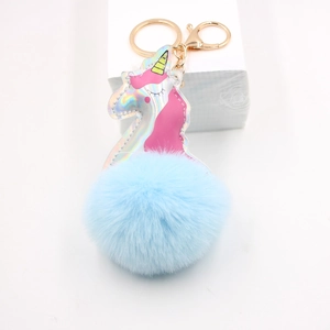 Close-up of laser leather unicorn plush keychain with golden metal ring and blue fur ball