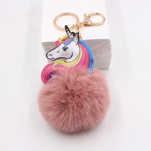 Detail of colorful unicorn pom pom keychain with pink faux fur and golden metal clasp