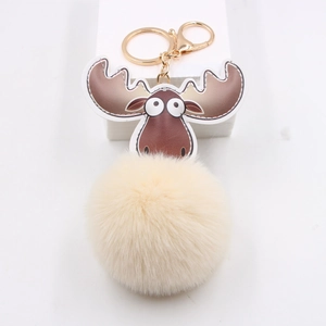 Détail du porte-clés peluche renne avec boule de fourrure jaune et fermoir or