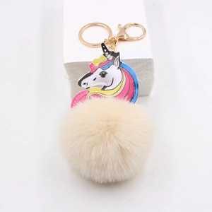 Detailed view of plush unicorn keychain with beige faux fur ball and gold metal clasp