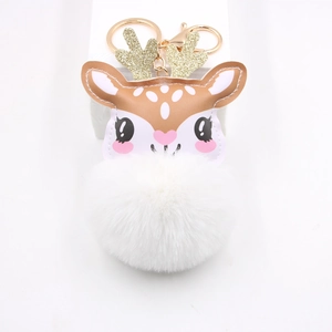 Close-up of cute reindeer plush keychain with gold antlers and soft white pompom