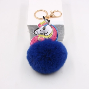 Detail of royal blue pompom unicorn keychain with gold metal lobster clasp and ring