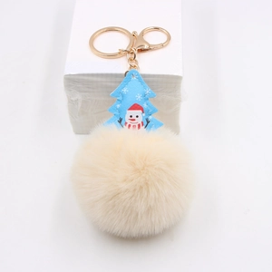 Detail of Christmas plush keychain featuring blue tree pendant and white faux fur pompom