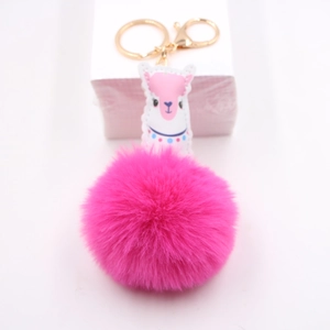 Détail d'un porte-clés pompon alpaga rose avec un fermoir mousqueton en métal doré
