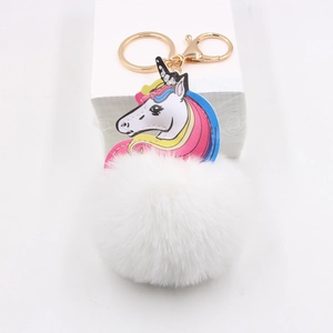 Close-up of fluffy unicorn keychain with white pom-pom and gold metal lobster clasp