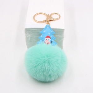 Close-up of mint green faux fur ball keychain with snowman leather Christmas tree charm