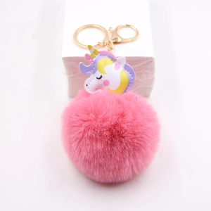 Detailansicht eines rosa Fellbommel-Schlüsselanhängers mit Einhorn-Anhänger und Goldclip
