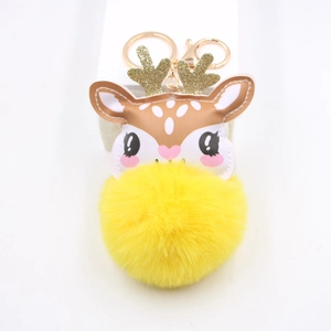Close-up of yellow plush reindeer keychain with golden antlers and metallic hardware