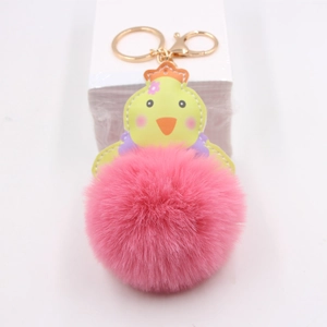 Détail du porte-clés poussin en peluche avec pompon rose et crochet en métal doré