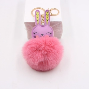 Detail of purple faux leather rabbit keychain with soft pink plush fur and gold metal ring