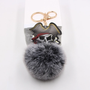Portachiavi teschio pirata punk con pompon in ecopelliccia grigia e anello dorato