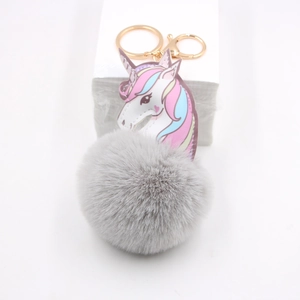 Close-up of a fluffy grey faux fur unicorn keychain with gold metal clasp and ring