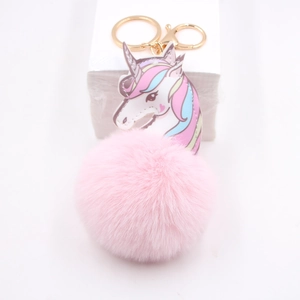 Close-up of a pink faux fur unicorn keychain with rainbow mane and golden metal clip