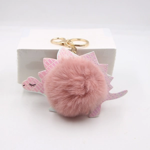 Detailed view of pink pom pom dinosaur keychain with holographic scales and gold lobster clasp