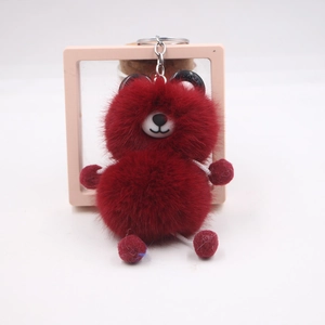 Close-up of fluffy burgundy plush bear keychain with soft texture and silver metal ring