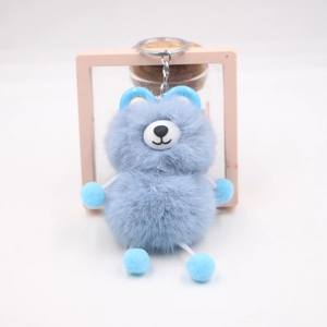 Close-up of sky blue plush bear keychain with metallic ring and soft fur texture