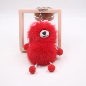 Close-up of red fluffy plush bear keychain with soft fur texture and silver metal ring