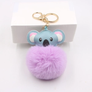 Detail view of light blue koala plush keychain with a soft lavender faux fur pompom ball