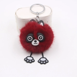 Détail d'un joli porte-clés raton laveur en peluche bordeaux avec pompon doux