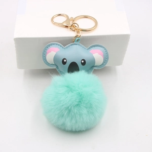 Detail view of cute koala plush keychain with blue leather head and green fur ball