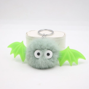 Detail of cute plush Halloween bat keychain with grey pompom and green wings