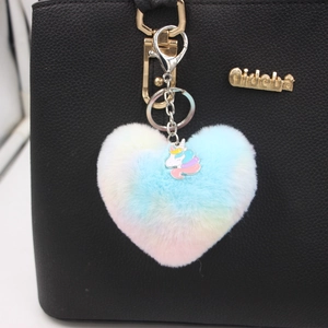 Dettaglio del portachiavi a cuore in peluche con unicorno attaccato a una borsa nera