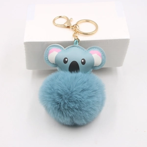 Close-up of sky blue faux fur koala pompom keychain with golden metal hook detail
