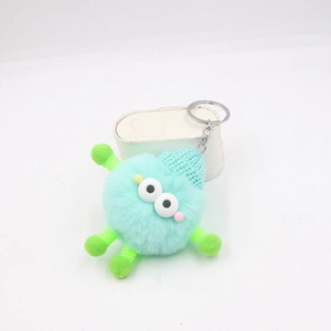 Détail d'un porte-clés en peluche vert menthe avec bonnet tricoté et anneau en métal