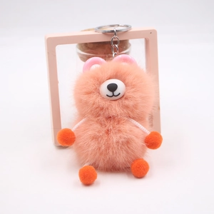 Detail of cute orange plush bear keychain with soft faux fur and metal ring connector