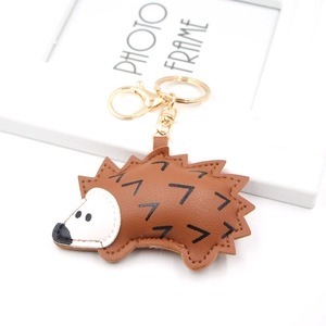 Macro detail of brown PU leather hedgehog keychain with fine stitching and golden clasp