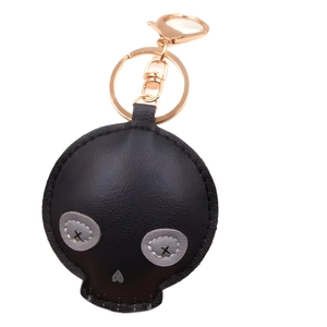 Creative black skull PU leather keychain with gold hardware on a white background