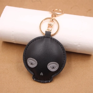 Detail view of the black textured leather skull keychain with golden lobster clasp