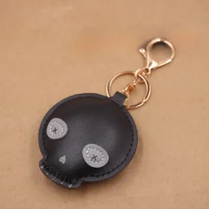 Close-up of black PU leather skull keychain with X-eye embroidery and golden metal hook