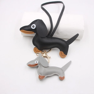 Detailed view of handmade leather dachshund charms in black and grey with refined stitching