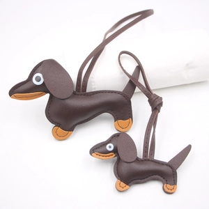 Close-up of brown textured leather dachshund charms with neatly hand-stitched details