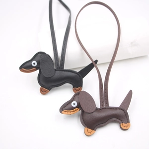 Detailed view of handmade leather dachshund bag charms in black and dark brown colors