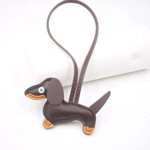 Detail of handcrafted brown leather dachshund charm with stitching and long strap