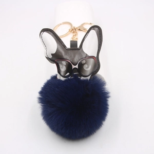 Détail d'un porte-clés bouledogue en cuir avec pompon bleu et anneau doré brillant