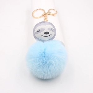 Gros plan d'un porte-clés pompon bleu ciel avec un adorable visage de paresseux