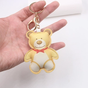 Cartoon yellow leather bear keychain with red bowtie and gold metal lobster clasp