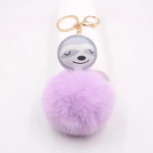 Détail du pendentif paresseux avec pompon en fourrure violette et porte-clés doré