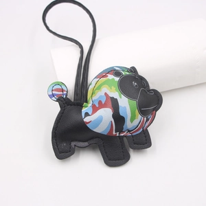Close-up of a handmade black leather animal charm with artistic colorful graffiti patterns
