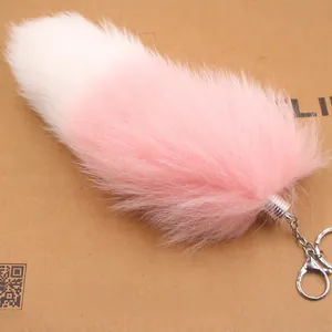 Détail du pendentif queue de renard en fourrure dégradée rose et blanc avec mousqueton