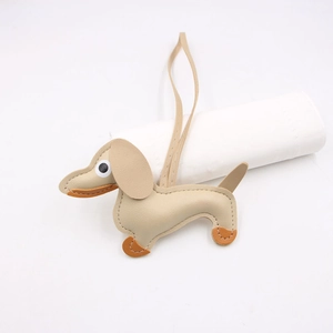 Detail of dachshund bag charm with orange contrast ears and handmade stitching on leather