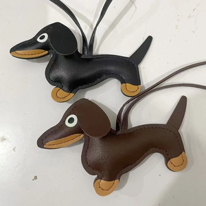 Detail showing black and dark brown leather dachshund bag charms with contrast stitching
