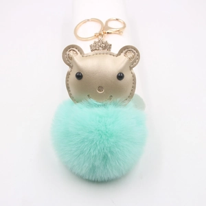 Détail de tête d'ours dorée avec couronne et pompon en fausse fourrure vert menthe