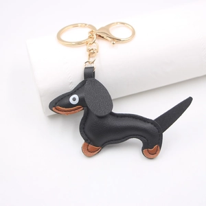Detail of black and brown leather dachshund keychain with polished gold hardware