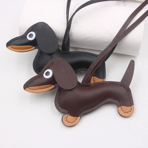 Close-up of black and brown leather dachshund bag charms with detailed lychee grain texture