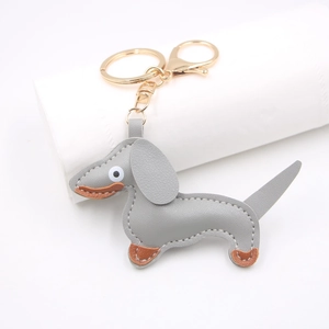 Detail showing grey leather dachshund charm with neat stitching and gold metal lobster clasp